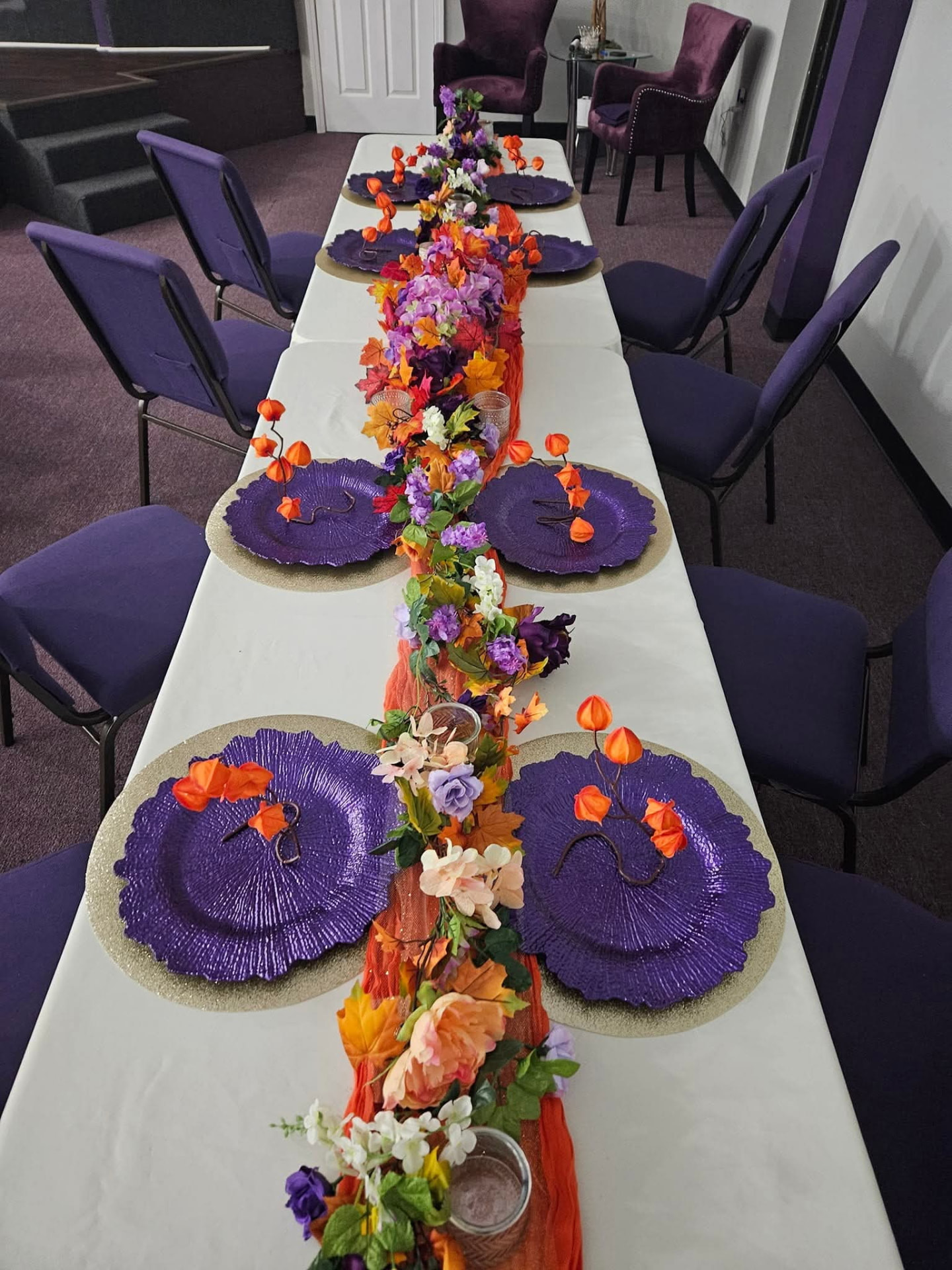 Fall tablescape with purple chargers and autumn floral runner